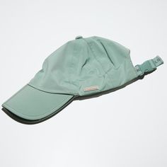 a light green hat laying on top of a white surface