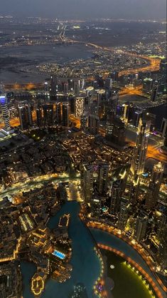 an aerial view of the city lights and buildings at night from high up in the sky