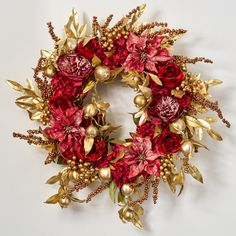 a red and gold christmas wreath with poinsettis