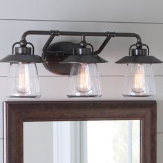 a bathroom vanity with three lights and a mirror