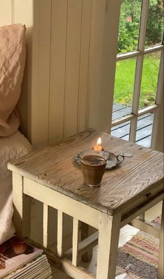 a small wooden table with a candle on it