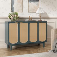 a sideboard with three panels and a lamp on top in a living room area