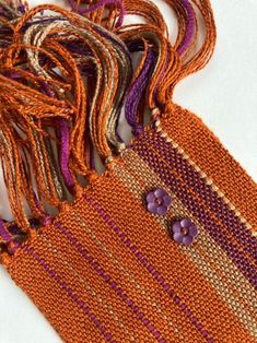 an orange purse with purple and tan trim