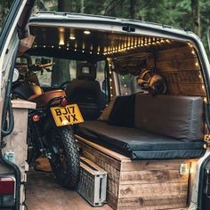 the back end of a van with a motorcycle in it's cargo area and an open trunk