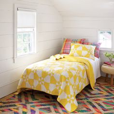 a bedroom with white walls and yellow bedding