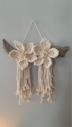 the wall hanging is decorated with white yarn and wood pieces, along with a candle