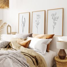 a bed with pillows, blankets and pictures on the wall