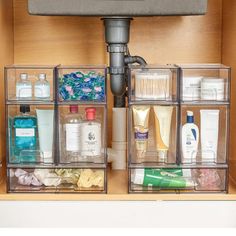 the under sink drawer is organized with clear bins