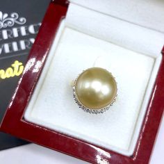 A lustrous pearl, cocktail ring is a need for every lady in the world. What could get you more attention than having this huge, exotic, and sparkling pearl ring on your finger while holding a glass of wine? We are presenting you with a Huge GOLDEN SOUTH SEA PEARL, absolutely natural color and TOP AA+ luster, 14 mm in size, surrounded by 22 pieces of hand-set F/VS superb quality diamonds, weighting at 0.64 carat. Set in handcrafted, one of a kind 18K solid white gold ring, weighting at 8.0 grams. Elegant Silver Pearl Ring For Party, Luxury Pearl Diamond Ring As Gift, Elegant Pearl Ring For Party, Diamond Pearl Ring With High Luster For Gift, Gift Pearl Ring With High Luster And Diamond, Elegant Pear-shaped Diamond Ring Gift, Holding A Glass Of Wine, Golden South Sea Pearls, Sea Pearl