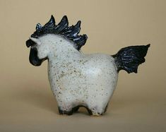 a ceramic figurine of a white horse with black wings