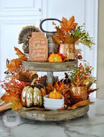 three tiered tray filled with autumn decorations