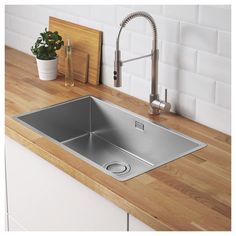 a stainless steel sink and faucet on a wooden countertop in a kitchen