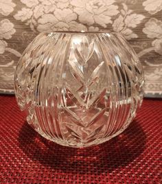 a clear glass vase sitting on top of a red table