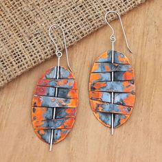 two oval shaped wooden earrings on top of a wooden table next to a burlock