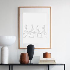 a black shelf with two vases and a framed drawing