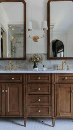 a bathroom with double sinks and two mirrors