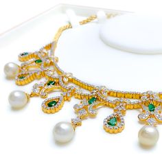 This exquisite 18k yellow gold necklace set, weighing 73.8 grams, features a luxurious design adorned with dazzling diamonds, pearls, and vibrant emeralds. The yellow gold finish enhances its elegant appeal, making it perfect for any special occasion. The set includes a necklace with a total diamond weight of 9.27 carats, featuring F-G color and VS quality diamonds. Complementing the diamonds are pearls weighing 42.14 carats and emeralds weighing 3.14 carats. The necklace has a length of 15 inch Elegant Hand-set Emerald Necklace In Yellow Gold, Elegant Yellow Gold Hand Set Emerald Necklace, Luxury Gold Emerald Necklace For Party, Luxury Diamond Necklace With Emerald In Gold Setting, Luxury Gold Emerald Necklace With Diamond Accents, Luxury Gold Emerald Diamond Necklace, Elegant Gold Emerald Necklace With Cubic Zirconia, Elegant Yellow Gold Emerald Necklace For Festive Occasions, Festive Yellow Gold Emerald Necklace