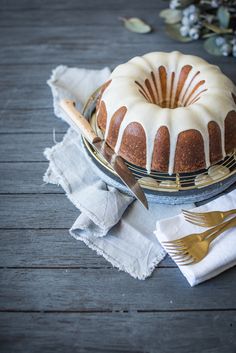 a bundt cake sitting on top of a plate next to a knife and fork