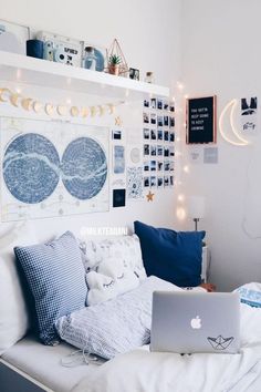 a laptop computer sitting on top of a bed in a room filled with pictures and lights