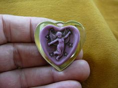 (Internal #C84-6)  Excellent, new, hand stained natural pine resin, hand-molded (reproduced from the original shell cameo) heart shaped cameo of a CHERUB CUPID full body with arms outstretched, surrounded by stars.  Pin/pendant in MAUVE PINK colored pine resin, antiqued and mounted on repro Victorian brass; cameo itself is 1-1/4" long x 1-1/8" wide (30 x 29 mm). Clasp pin/pendant glued on back horizontally. BRASS IS A GOLD COLOR. Superb detail for a small cameo, from the movement of Cupid, his a Antique Heart-shaped Brooches As Gifts, Antique Heart-shaped Brooch For Gift, Antique Heart-shaped Brooches For Gifts, Angel With Bow And Arrow, Cupid Cherub, Angelic Aesthetic, Pine Resin, Arrow Heart, Gemini Season