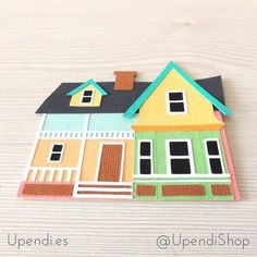 a paper cut out of a house on top of a wooden table