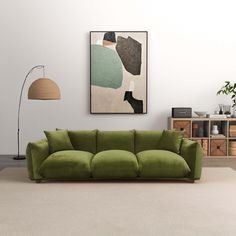 a living room with a large green couch and two lamps on the wall above it