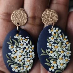 a pair of earrings with flowers painted on them