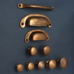 several brass handles and knobs on a blue surface