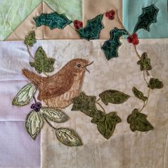 a piece of cloth with a bird and holly leaves on it, surrounded by other fabric pieces