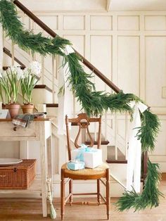 a wooden chair sitting under a banister filled with greenery