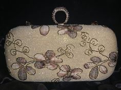 Elevate your style with our cream and purple floral clutch, a masterpiece of elegance and femininity. Perfect for both casual outings and special occasions, this clutch combines soft cream leather with delicate purple floral patterns, creating a harmonious blend of sophistication and charm. Crafted with meticulous attention to detail, each clutch features intricate floral embroidery or embossing, ensuring a unique and eye-catching design. The compact size makes it convenient to carry yet spaciou Beige Feminine Evening Bag, Feminine Beige Evening Bag, Feminine Beige Rectangular Evening Bag, Feminine Beige Evening Bag For Formal Occasions, Elegant Beige Evening Bag For Formal Occasions, Embellished Cream Rectangular Clutch, Cream Embellished Rectangular Clutch, Gold Feminine Clutch For Formal Occasions, Feminine Gold Rectangular Clutch