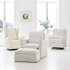 a living room filled with white furniture next to two windows and a potted plant