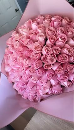 a large bouquet of pink roses in a box