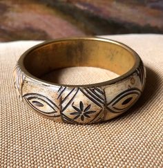 This wonderful tribal bone bangle bracelet is in great vintage condition. It is carved bone with brass spacers. It is 1" wide and 3 1/4: round. The inside measure 2 1/2' round. Most vintage items are old and pre-owned so they may have some degree of wear and imperfections and are sold in as-is condition. Sorry, all sales are final so this item is non-refundable. So please look it over carefully and ask me any questions before making the purchase. Due to the fact that I sell many vintage items of different sizes and weights, if you are purchasing more then one item I will adjust the shipping price. I always do my best to provide accurate shipping quotes. Colors may vary due to individual computer monitor settings. All my items come from a smoke-free environment. I try to recycle packaging m Vintage Adjustable Cream Bracelets, Handmade Vintage Cream Bracelets, Vintage Adjustable Cream Bracelet, Vintage Handmade Cream Bracelets, Bohemian Etched Bangle Bracelet, Vintage Adjustable Bangle For Festivals, Bohemian Etched Cuff Bangle Bracelet, Bohemian Bone-colored Jewelry For Festival, Bohemian Bone Colored Jewelry For Festivals