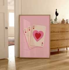 two playing cards in front of a door with a pink background and heart on it