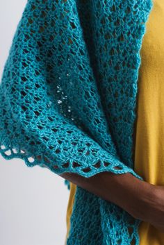 a woman wearing a blue crocheted shawl