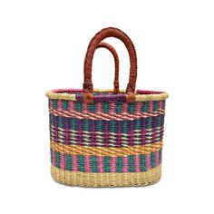 a multicolored basket with leather handles on the handle and bottom, sitting in front of a white background