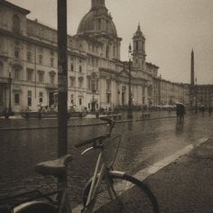 a bicycle parked on the side of a wet street