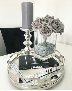 a silver candle holder with flowers and books on it