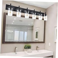 a bathroom with a large mirror and four lights on the wall over the sink area