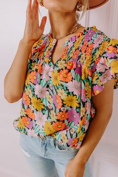 - Embrace feminine florals this season with this sweet top! - Unlined material with a colorful floral print - A ruffled v-notched neckline - A smocked upper bodice - Short flutter sleeves - A relaxed silhouette that ends in a rounded hemline Spring Floral Print V-neck Smocked Top, Spring Floral Print Smocked Top, Multicolor Short Sleeve Smocked Top For Spring, Multicolor Smocked Top With Short Sleeves For Spring, Multicolor V-neck Tops With Ditsy Floral Print, Summer Multicolor Smocked Top With Floral Print, Summer Multicolor Floral Print Smocked Top, Multicolor Cotton Smocked Top With Floral Print For Summer, Casual V-neck Smocked Top With Floral Print