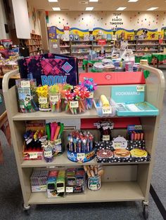 a book store filled with lots of books and candy on top of a metal cart