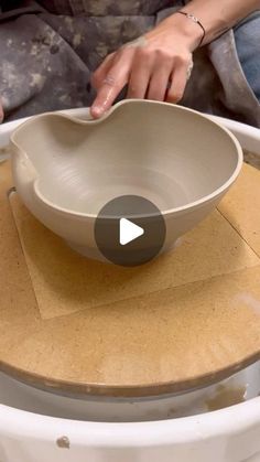 a person holding a bowl on top of a table