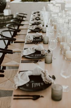 a long table is set up with place settings and napkins for the guests to sit down