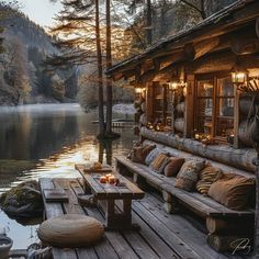 a wooden dock sitting next to a lake filled with lots of pillows and candles on top of it