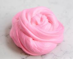 a pink ball of yarn sitting on top of a white countertop next to a marble surface