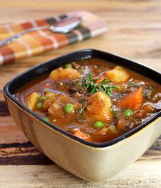 a bowl of stew on a wooden table