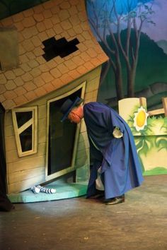 a man is standing in front of a fake house