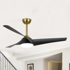 a ceiling fan that is hanging from the ceiling in a room with white walls and black railings