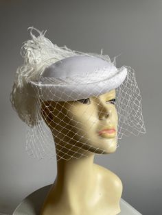 Great condition white vintage 1980s ladies hat. White fabric pillbox hat with hat elastic to hold in place.   white Veil and feather puff detail at the back of hat.  Stunning hat, lined and in good condition. Vintage White Fascinator For Evening, Vintage White Evening Fascinator, Vintage White Hat Headpiece, White Hat For Vintage Events, Vintage White Fascinator Hat, White Vintage Cloche Fascinator, Vintage White Cloche Fascinator, White Vintage Fascinator Hat, Vintage White Fascinator With Curved Brim